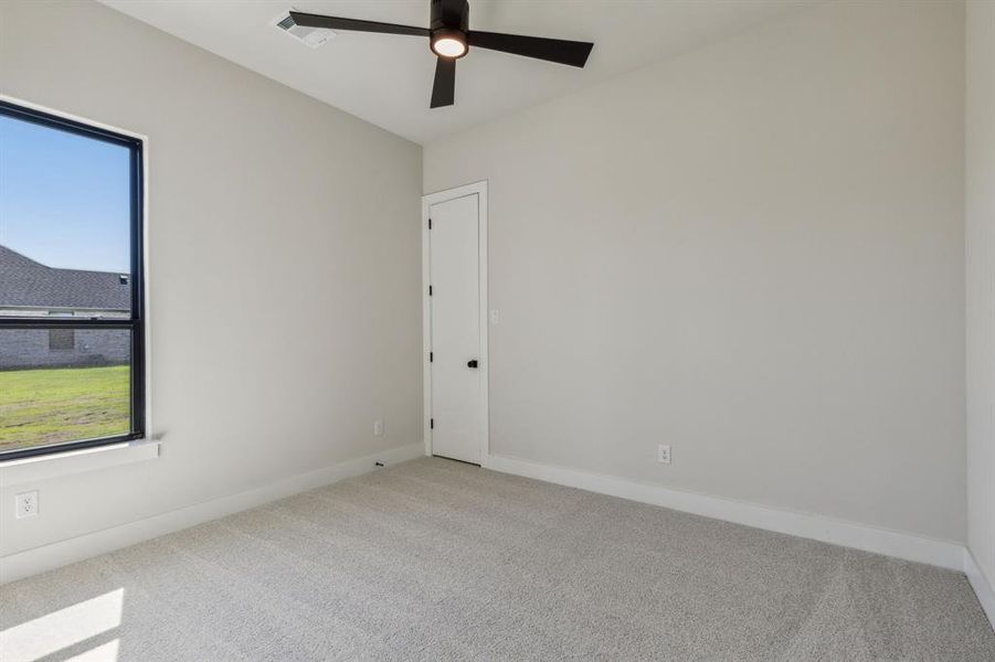 Carpeted spare room featuring ceiling fan