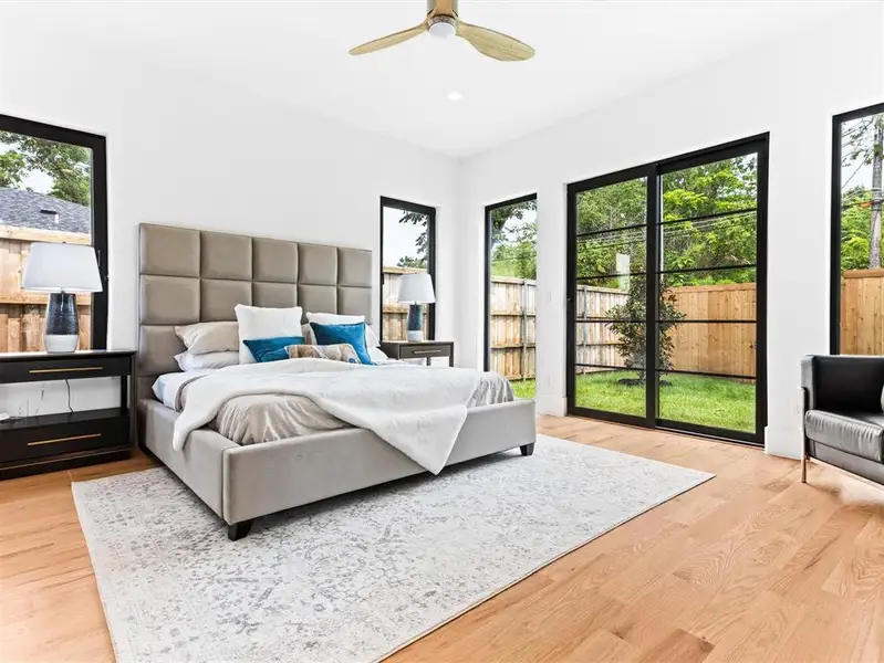 Bedroom featuring light hardwood / wood-style floors, multiple windows, and ceiling fan