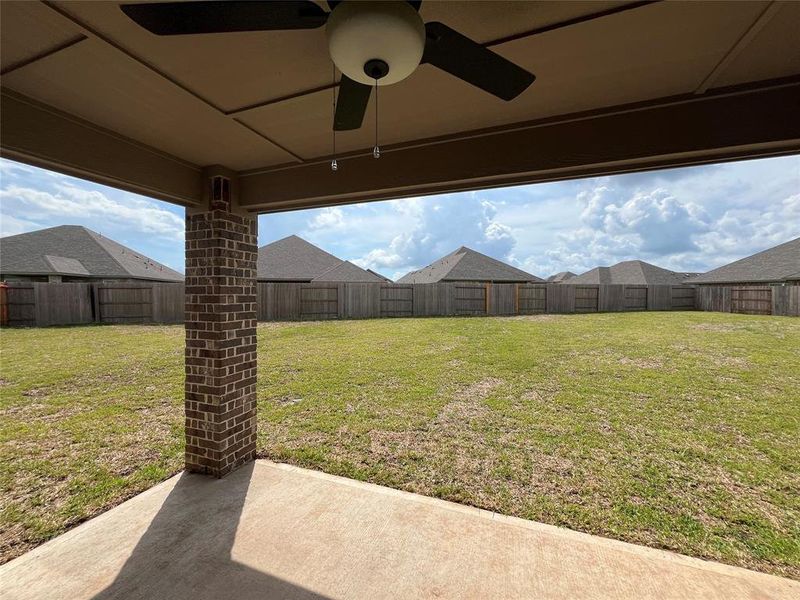 The back covered patio overlooks the oversized, fenced and  landscaped back yard.