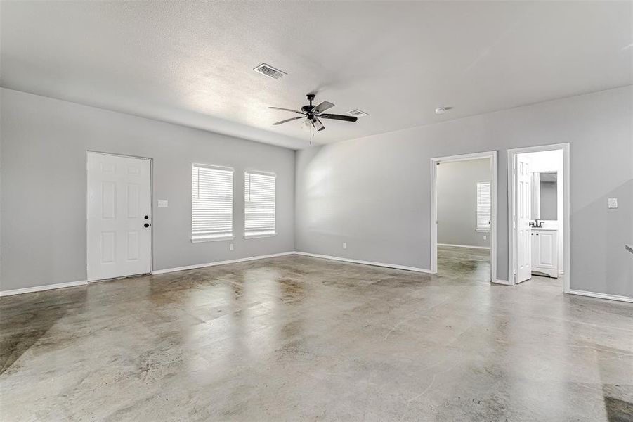 Unfurnished room with concrete floors and ceiling fan