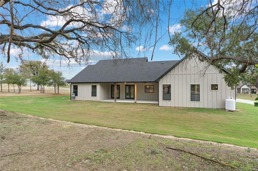 Rear view of property with a lawn