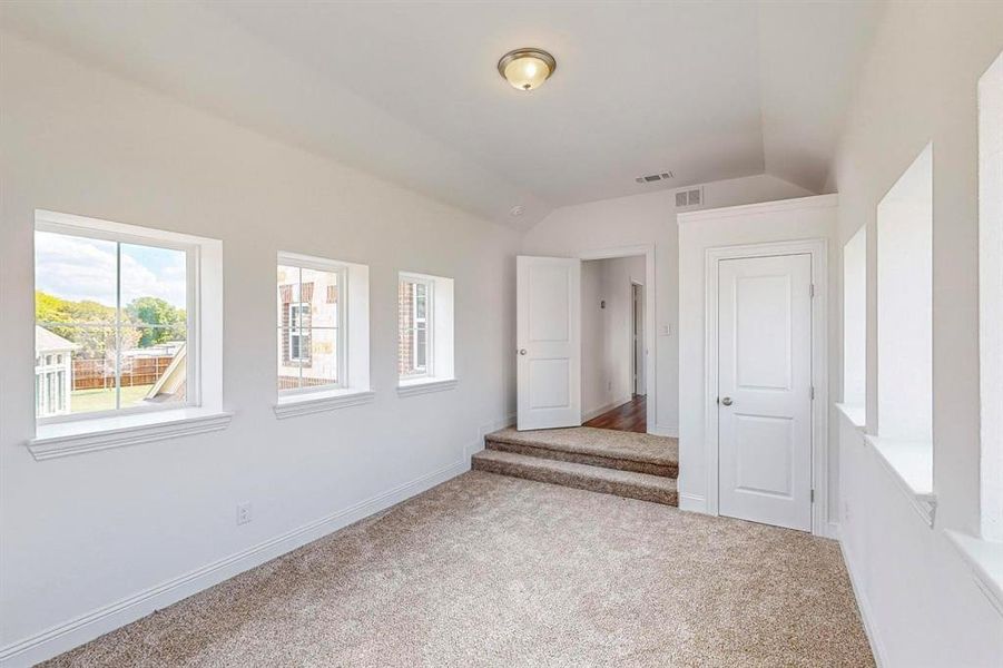 Upstairs, we have the 5th Bedroom, complete with closet, vaulted ceiling and windows all around. It could easily be converted into a media room, playroom, dance area, man cave, or office. The possibilities are endless!