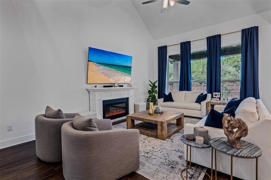 Living room featuring dark hardwood / wood-style floors, high vaulted ceiling, and ceiling fan