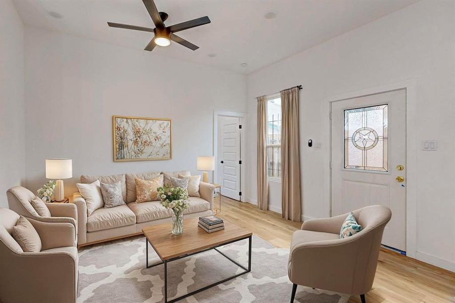 Living room with ceiling fan and light hardwood / wood-style floors