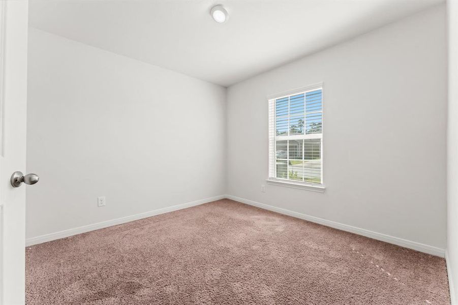 This secondary bedroom features lush carpeting, sunny window with blinds, ceiling light, and wall closet.  It has hallway access to a full bath.