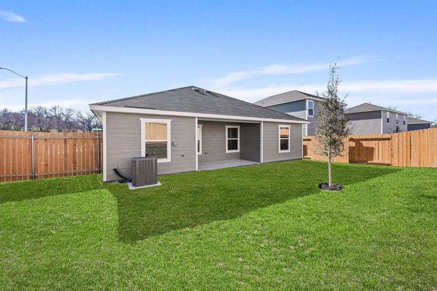 Rear view of property featuring cooling unit, a yard, and a patio area