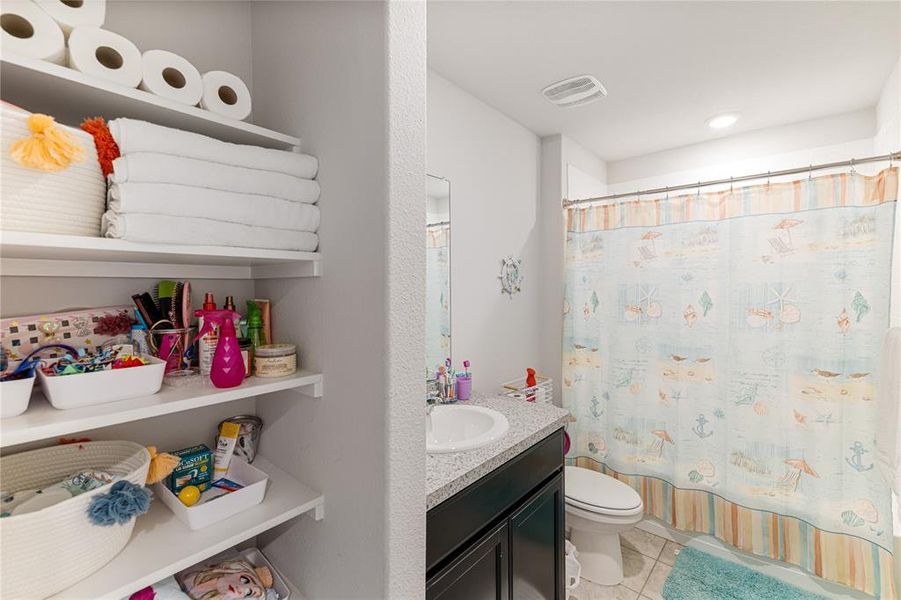 Bathroom featuring vanity, tile patterned flooring, toilet, and a shower with shower curtain