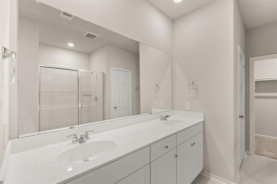 The en-suite bathroom offers a spa-like atmosphere with its elegant design, high end finishes, and tasteful lighting, creating a retreat within your own home.