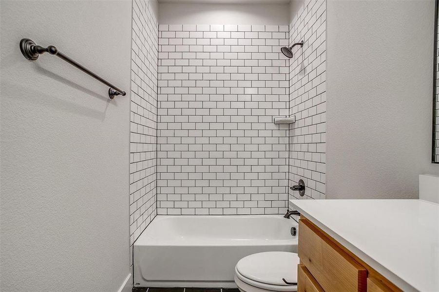 Full bathroom featuring vanity, toilet, and tiled shower / bath