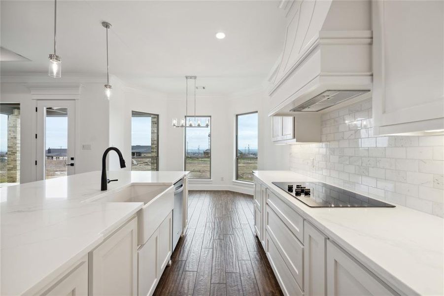 Kitchen with dark wood-type flooring, black electric stovetop, custom exhaust hood, and white cabinets