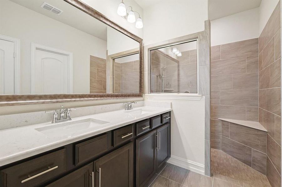 Bathroom with vanity and tiled shower