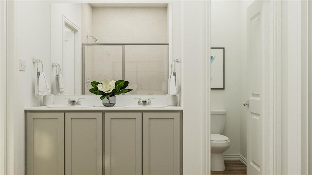 Bathroom with dual vanity, hardwood / wood-style floors, and toilet