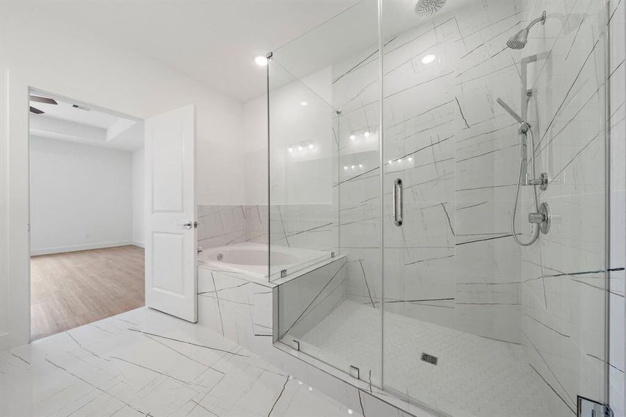 The Claudia has a beautiful Large Primary  bathroom with designer Tile, glass shower, and soaking tub.