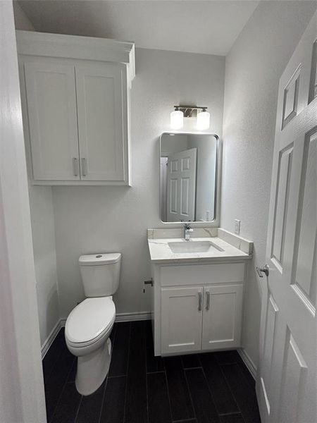 Half bathroom featuring toilet and vanity