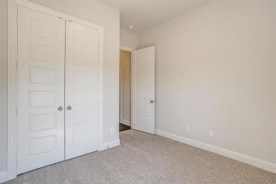 Unfurnished bedroom with light colored carpet and a closet