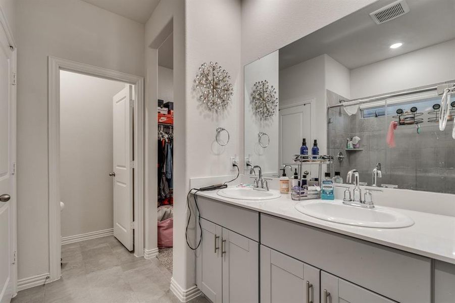 Bathroom with vanity, tile patterned flooring, and an enclosed shower