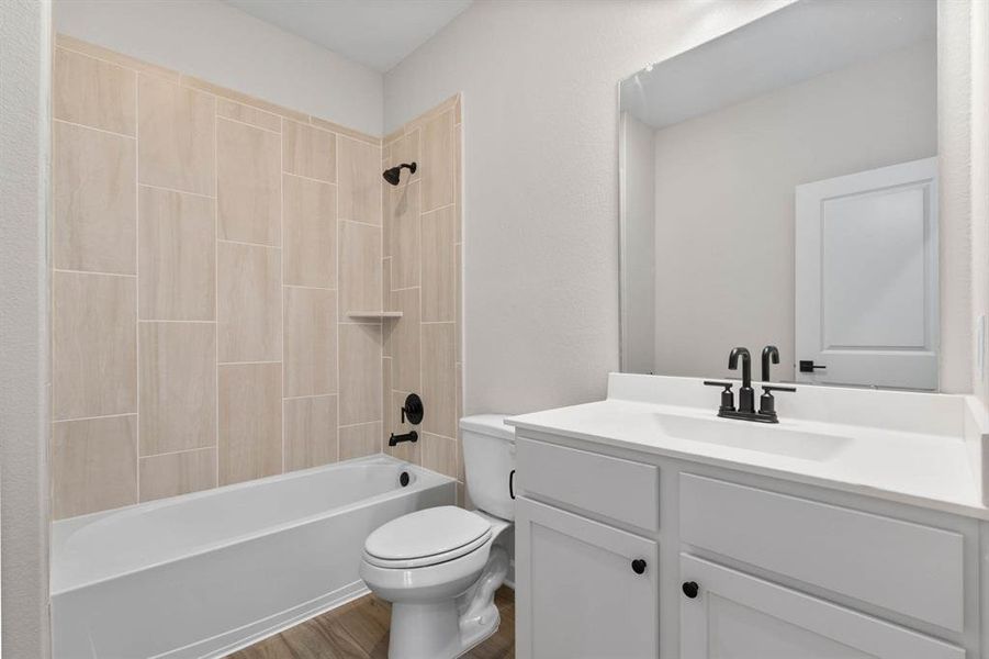 The secondary bathroom features a tiled tub/shower combination.