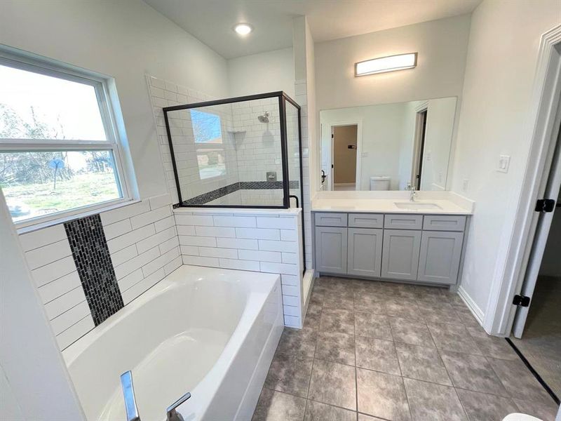 Bathroom with vanity, tile patterned floors, and separate shower and tub