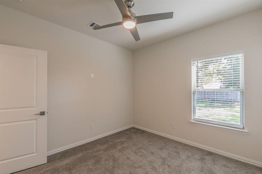 Carpeted empty room with ceiling fan