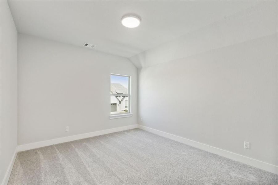 Spare room with lofted ceiling and carpet floors