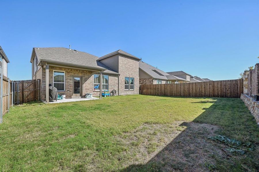 Back of house with a yard and a patio area