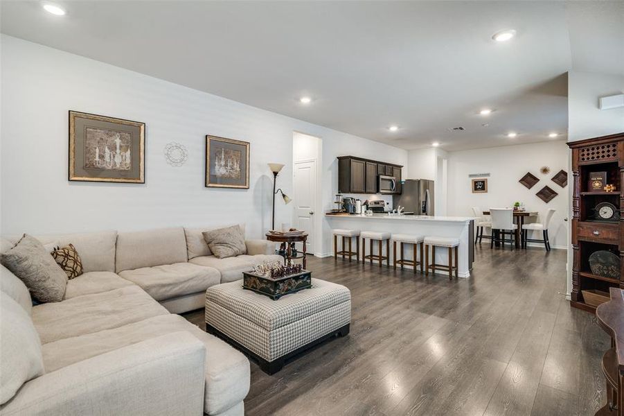 Living room with lofted ceiling and dark wood-type flooring