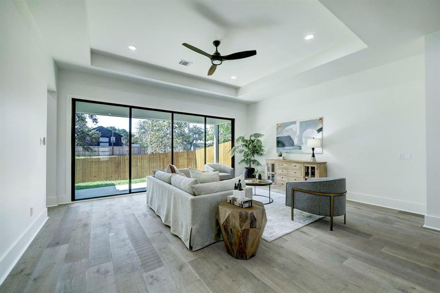 Tray ceiling inset with recessed lighting creates its own space within the open floor plan.