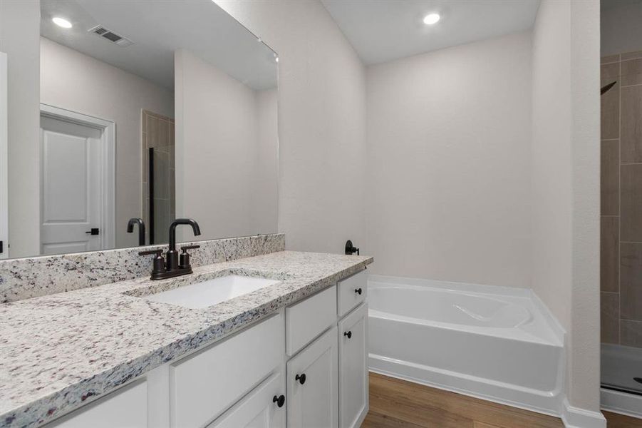 The primary bathroom is the perfect place to unwind after a long day. From the stylish vanity to both a tiled walk-in shower and a separate soaking tub, your spa like bathroom awaits.