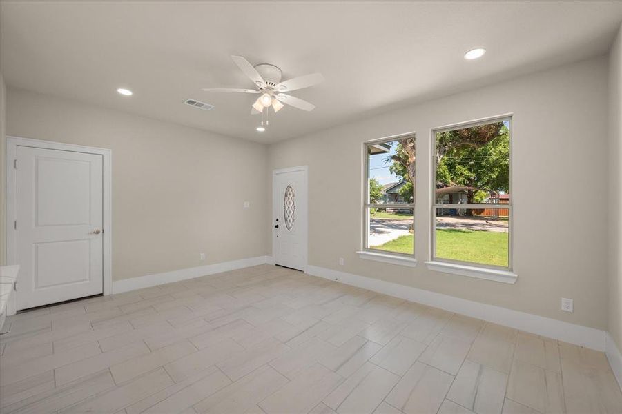 Unfurnished room featuring light tile patterned floors, a healthy amount of sunlight, and ceiling fan