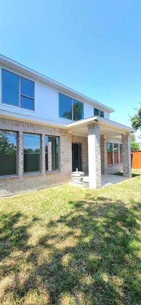 Rear view of house featuring a patio area and a yard