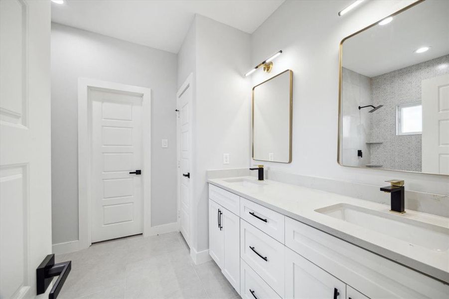 The primary bathroom features dual vanities and matte black finishes