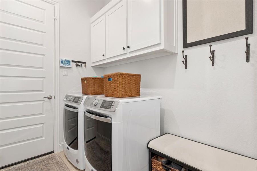 Washroom featuring washer and dryer and cabinets