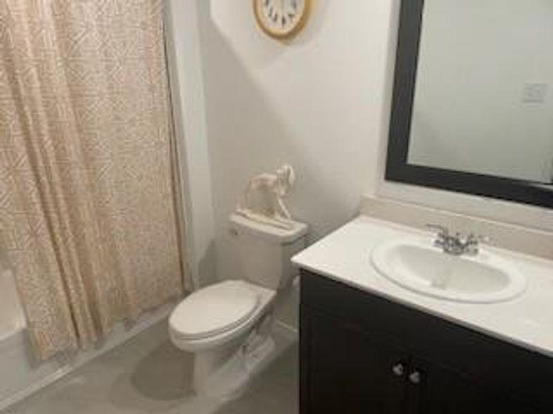 Full bathroom featuring vanity, toilet, and shower / bathtub combination with curtain