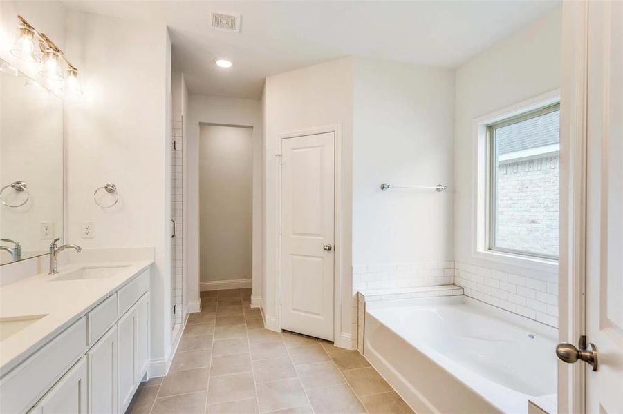 Bathroom featuring vanity, a bathtub, and tile patterned floors