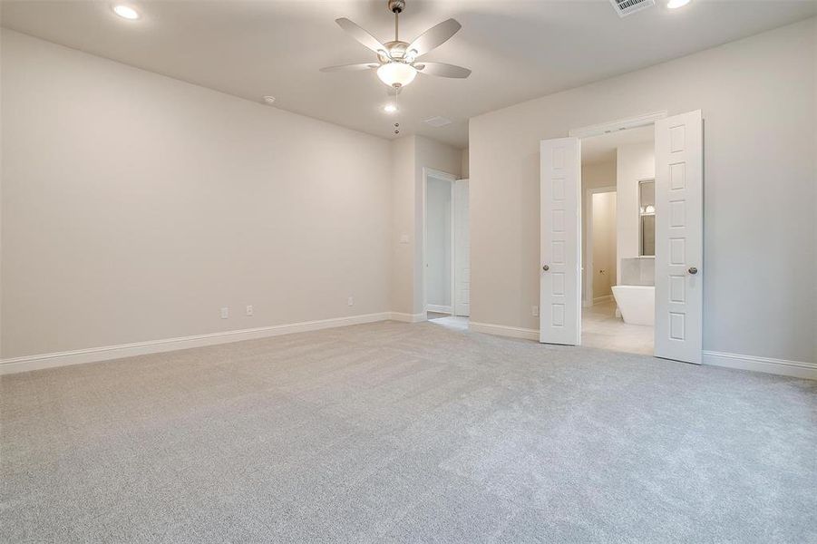 Unfurnished bedroom with light carpet and ceiling fan