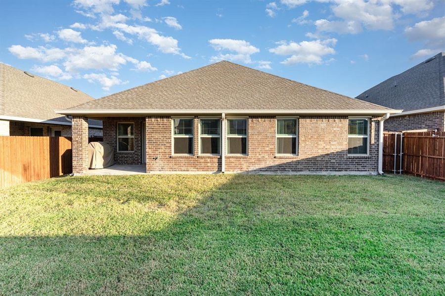 Back of house with a patio and a yard