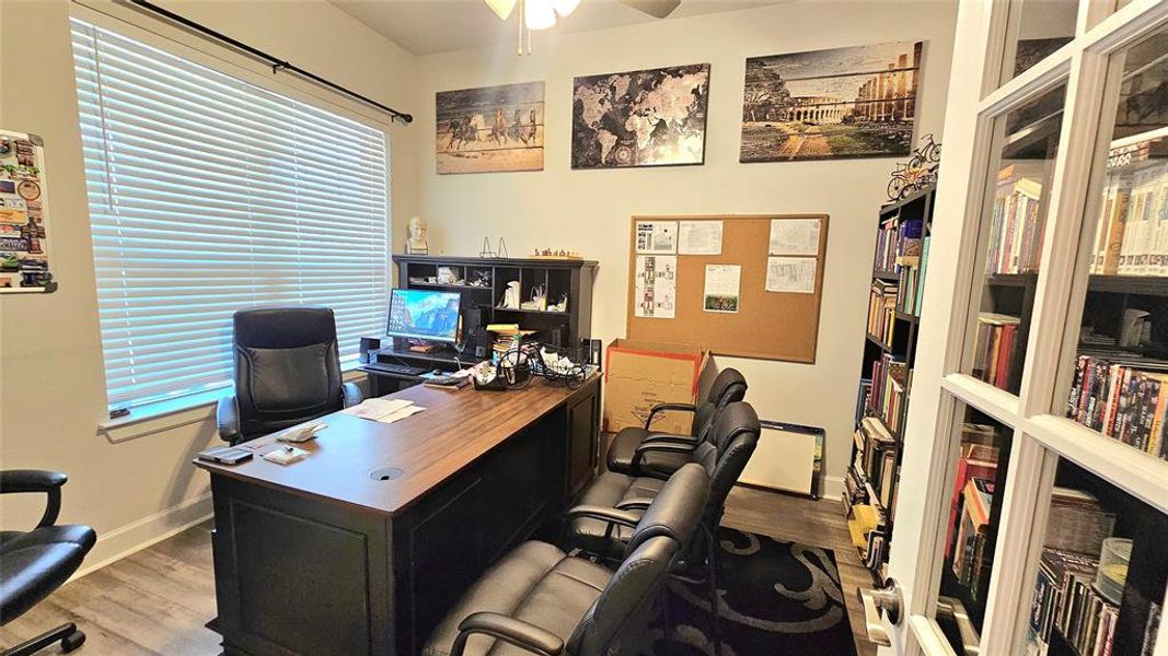 Office area with hardwood / wood-style flooring and ceiling fan