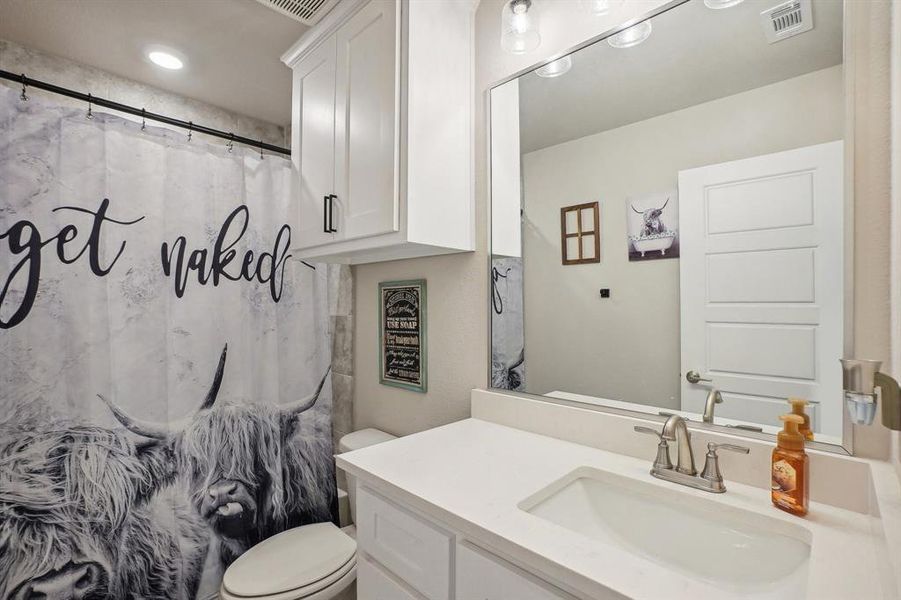 Bathroom with vanity, toilet, and a shower with curtain