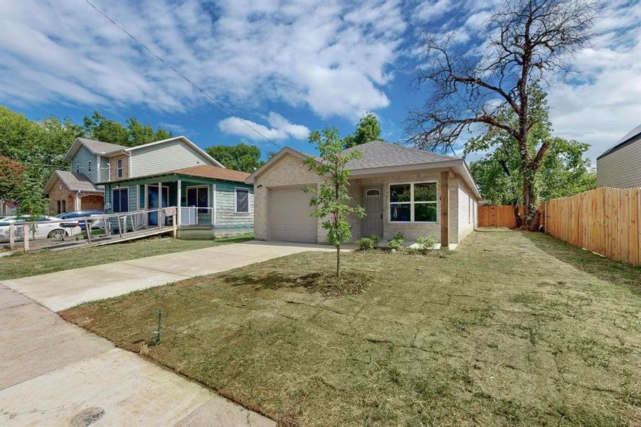 View of front facade with a garage, a front lawn, and covered porch