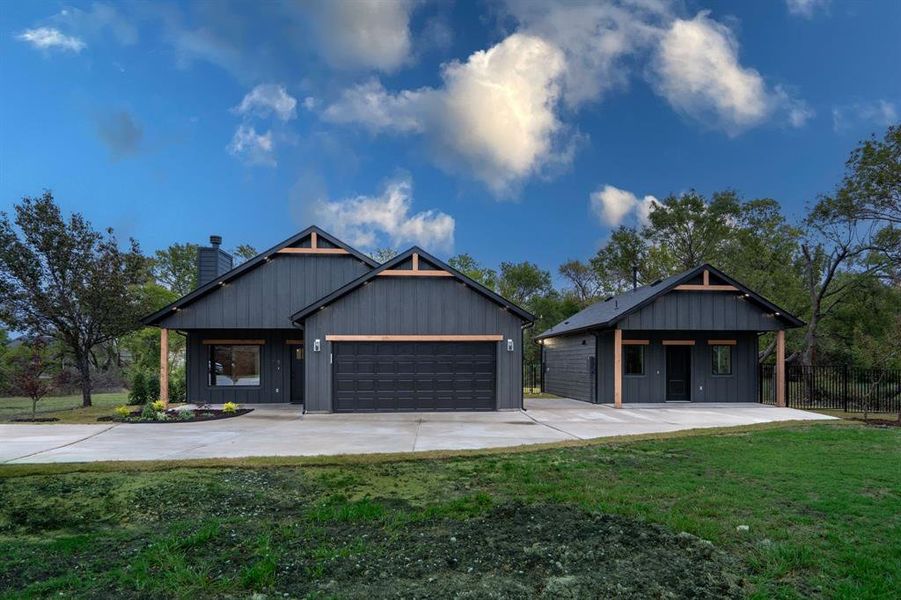 View of front of property with a garage and a front lawn