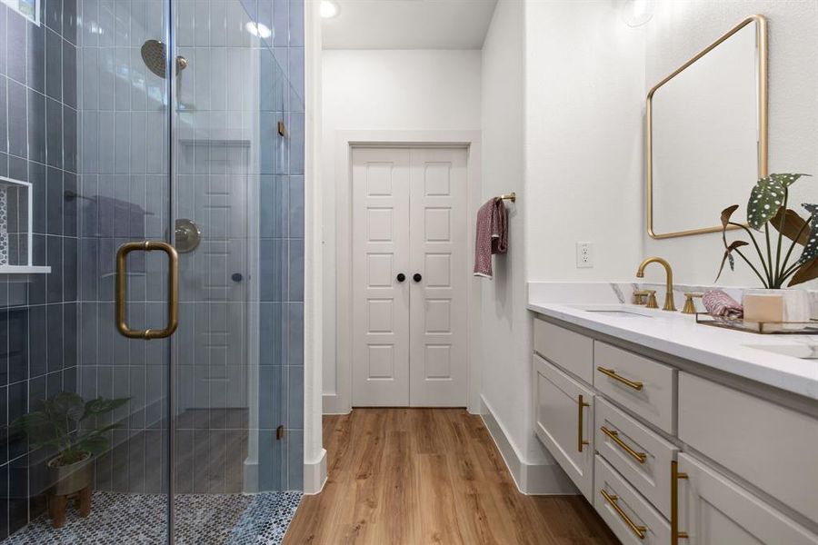 Bathroom with vanity, hardwood / wood-style flooring, and an enclosed shower