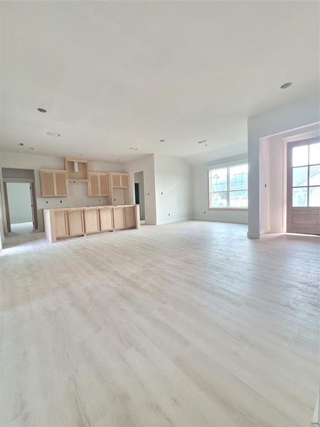 Living room featuring luxury vinyl light hardwood / wood-style floors, view of dining room and wooden front door