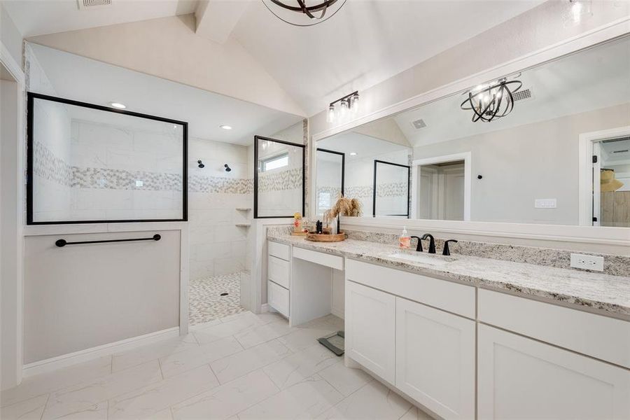 Bathroom with lofted ceiling with beams, vanity, and tiled shower