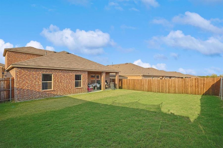 Back of property with a lawn and a patio area