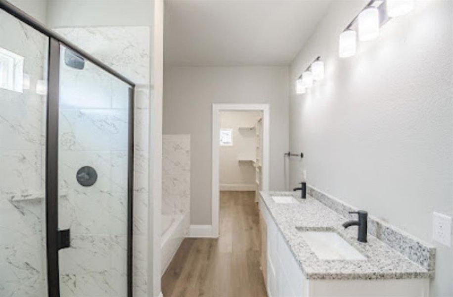 Bathroom with a shower with door, wood-type flooring, and double sink vanity