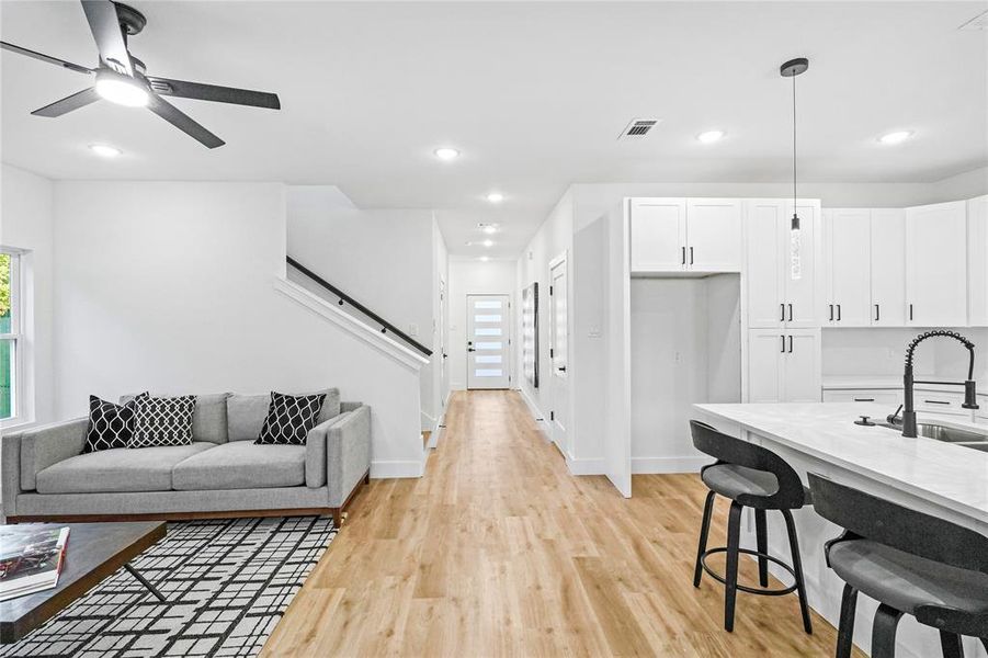 Living room featuring sink, ceiling fan, and light hardwood / wood-style flooring