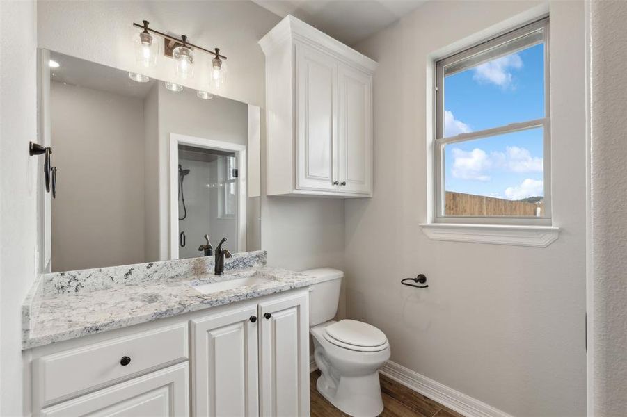 Bathroom featuring hardwood / wood-style floors, vanity, and toilet