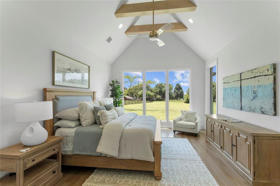 Primary Bedroom with a high, vaulted ceiling, overlooking the backyard space.