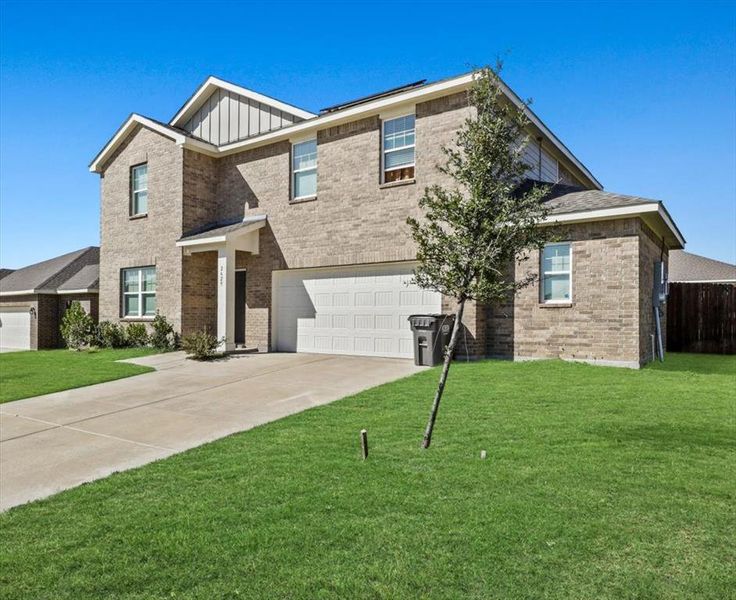 View of front of home featuring a front yard and a garage