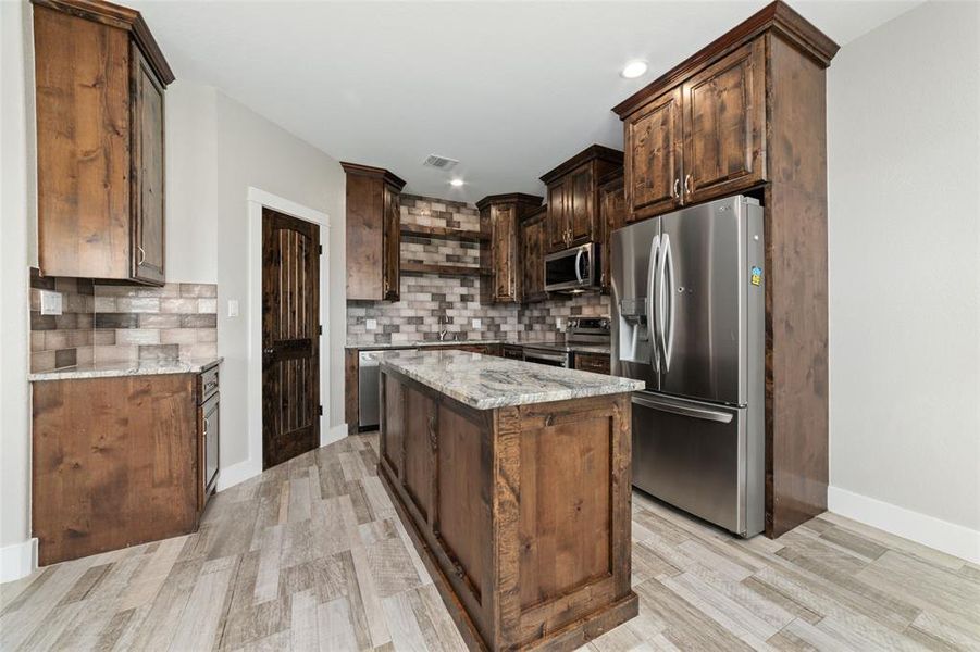 Stainless steel appliances enhance the kitchen's modern appeal, offering durability and sleek design. The soft=-closed cabinets, drawers, gorgeous granite countertops not only add a touch of elegance but also provide ample space for food preparation and entertaining.